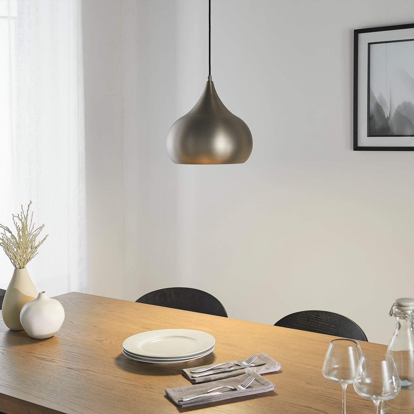 A dining room with a table and chairs showcasing elegant interior decor featuring a Kikiathome.co.uk Brosser Pendant Light.