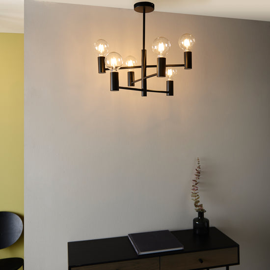 An Interior decor piece, Studio 6 Ceiling Light, hangs above a desk in a room.