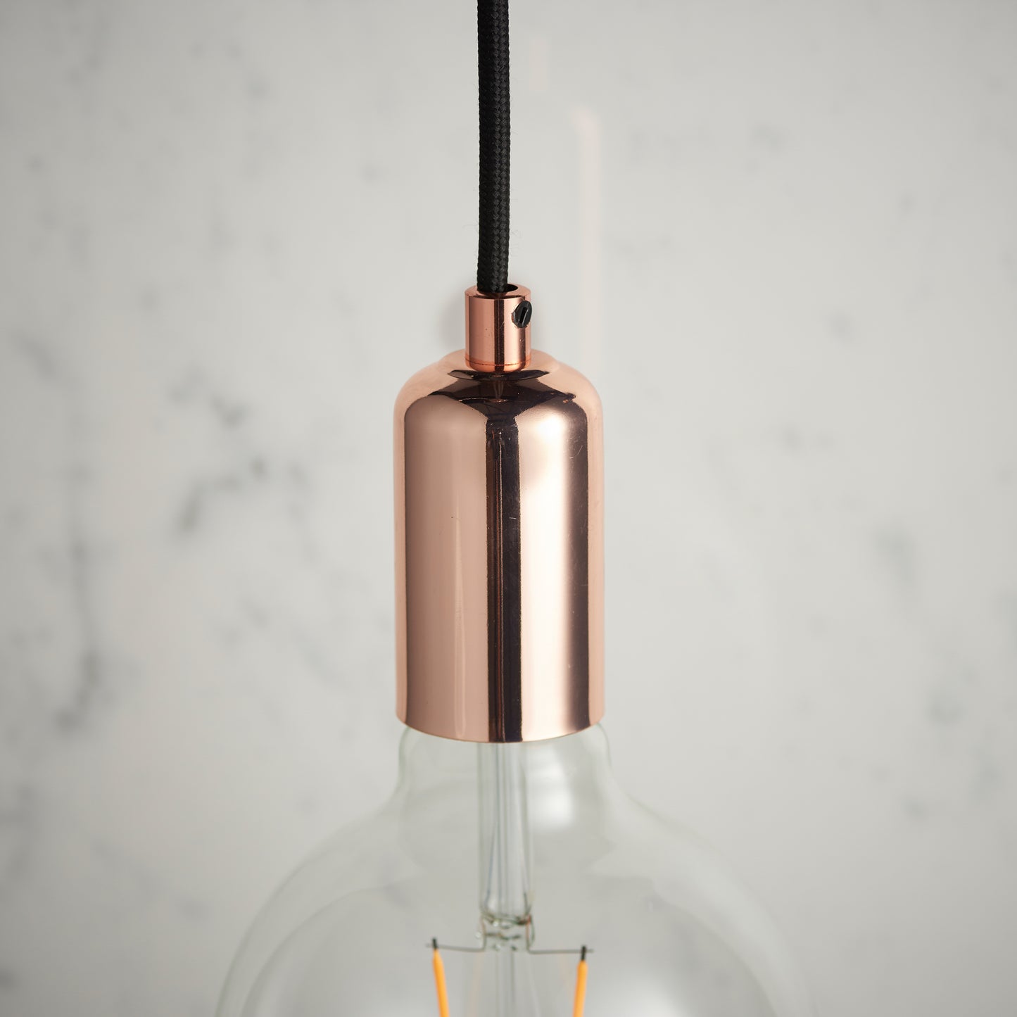 A Copper Pendant Light hanging on a marble countertop from Kikiathome.co.uk, perfect for home decor.