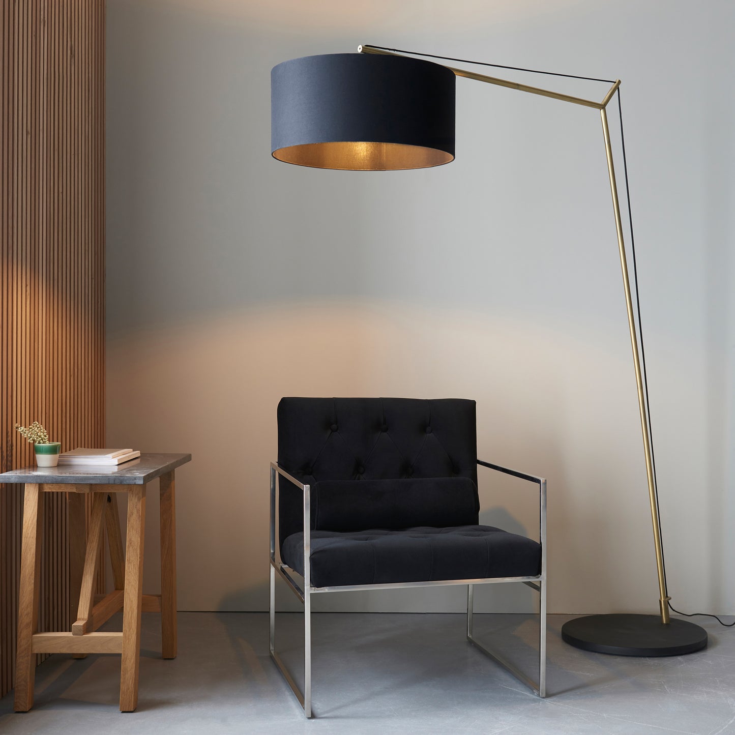 A black chair paired with an interior decor Kikiathome.co.uk Buckland Floor Lamp Antique Brass.