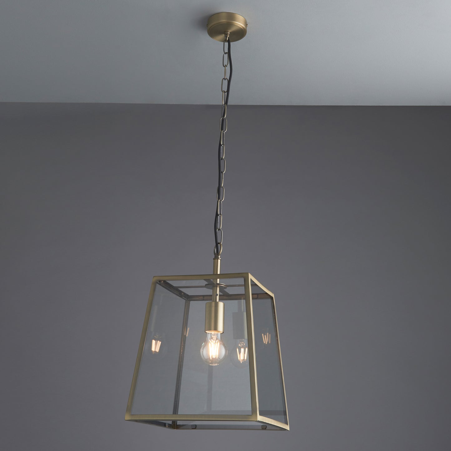 A Hurst Pendant Light Antique Brass from Kikiathome.co.uk with a clear glass shade for home interior decor.
