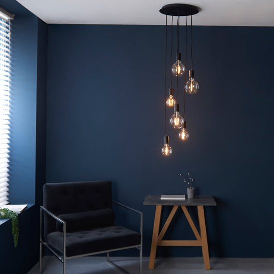 A room with a Studio 6 Pendant Light Matt Black chair, showcasing interior decor.