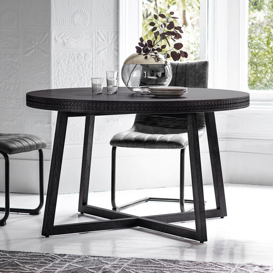 A Dartington Boutique Round Dining Table with two chairs and a vase, perfect for interior decor and home furniture.