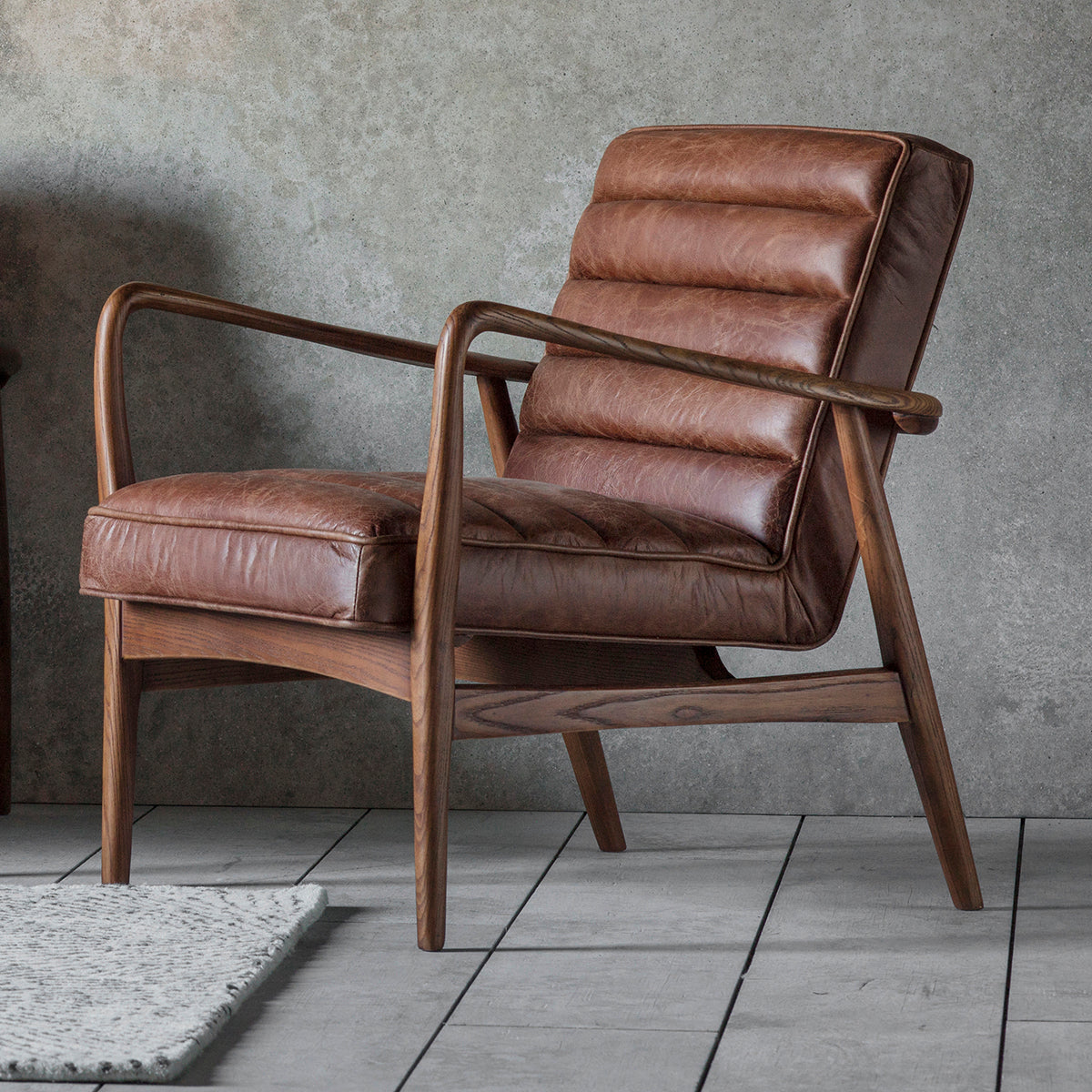 A Vintage Brown Leather lounge chair in front of a grey wall, made by Kikiathome.co.uk for home furniture and interior decor.