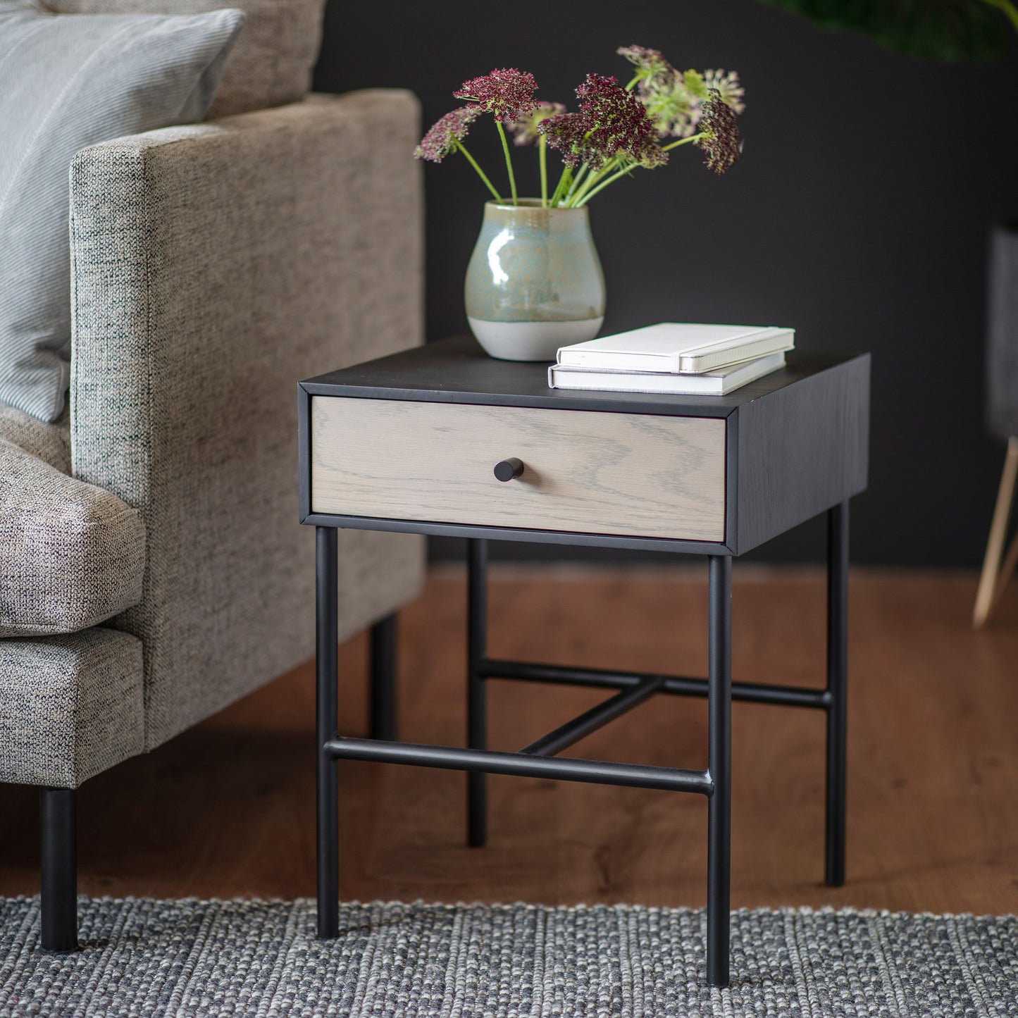 A Prawle 1 Drawer Bedside Table from Kikiathome.co.uk with a drawer and a vase, perfect for home furniture and interior decor.