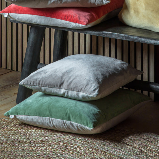 Three Cotton Velvet Cushion Sage 500x500mm by Kikiathome.co.uk stacked on top of a wooden bench for interior decor.