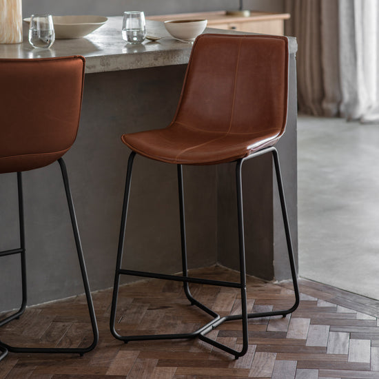 A pair of Slapton Stool Brown (2pk) 480x550x975mm bar stools from Kikiathome.co.uk enhancing the interior decor of a kitchen.