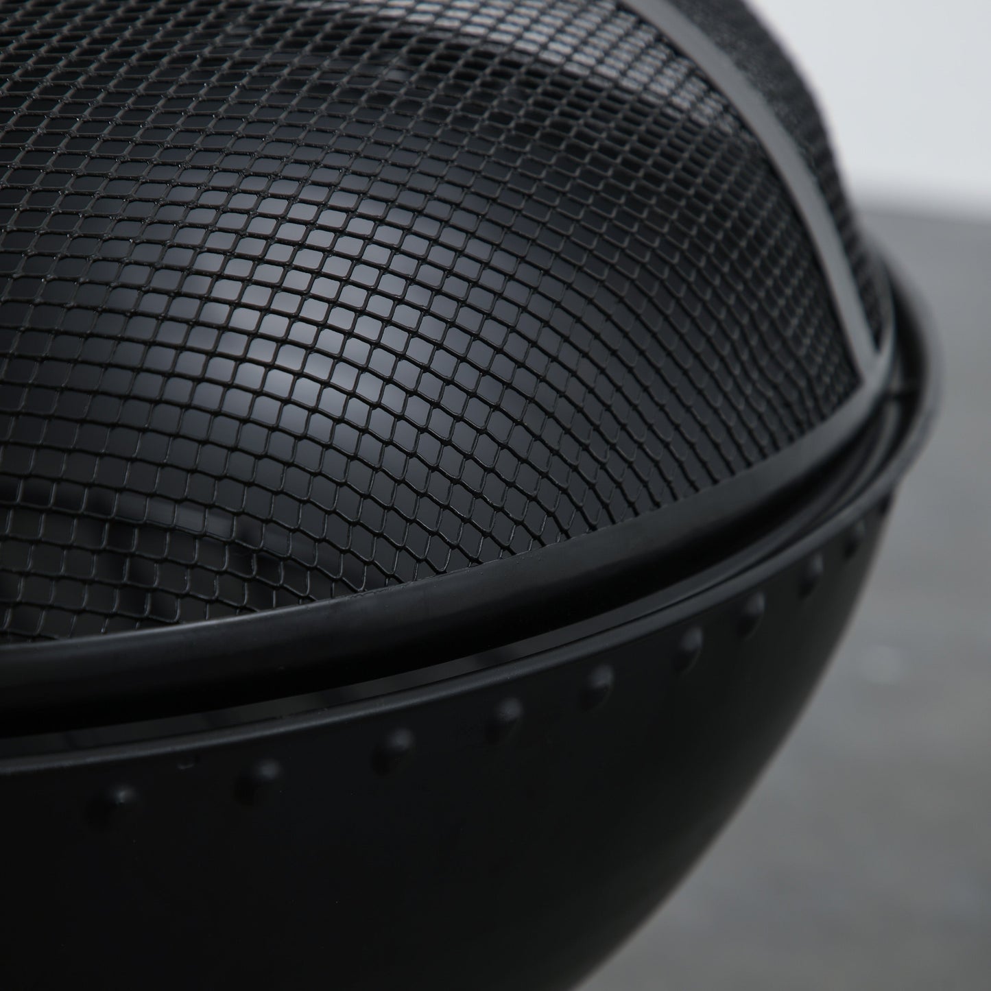 A close-up of the Kikiathome.co.uk Diptford Firepit, a black mesh fire pit perfect for home furniture or interior decor.
