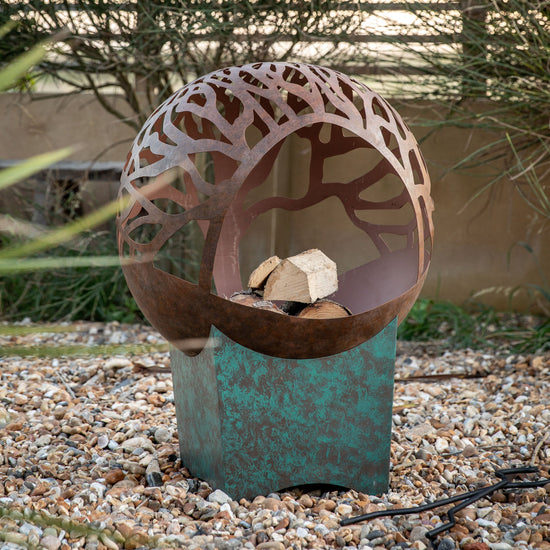 A visually stunning Kikiathome.co.uk Brushford Firepit enhances interior decor with a tree in it.