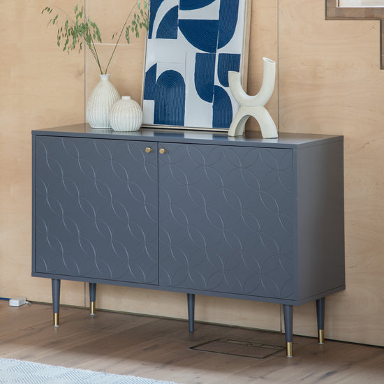 A 1200x400x790mm grey Thurlestone 2 Door Cabinet, perfect for home furniture and interior decor, showcased against a wooden wall on Kikiathome.co.uk.