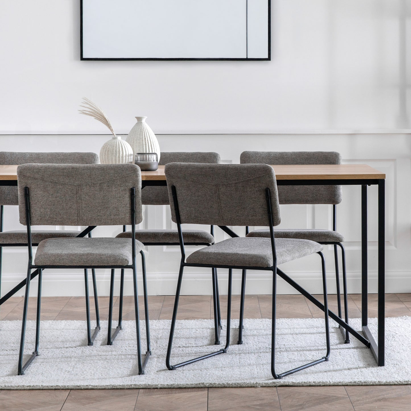 A Staverton Dining Table 1800x900x750mm with four chairs and a framed picture, ideal for interior decor or home furniture enthusiasts, from Kikiathome.co.uk.