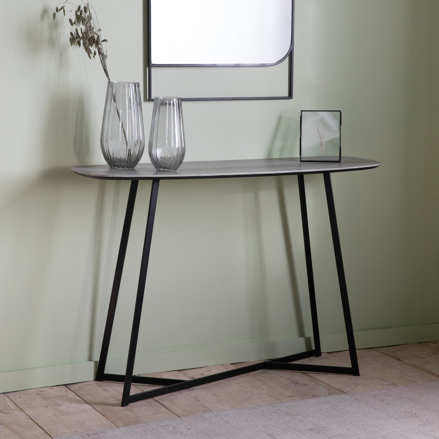 A Finsbury Console Table Oak Effect 1200x400x800mm with a mirror and vases for interior decor.