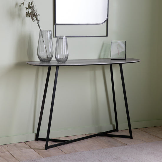 A Finsbury Console Table Oak Effect 1200x400x800mm with a mirror and vases for interior decor.