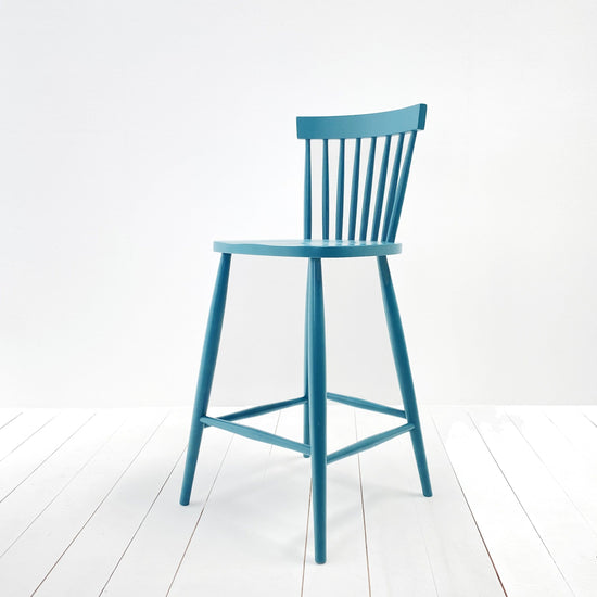 Interior decor, Home furniture: A Kiki Spindle Back Bar Stool displayed against a white wall.