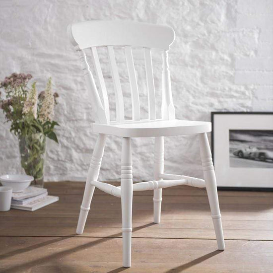 A pair of Kiki farmhouse chairs sitting on a farmhouse wooden floor with solid build quality.