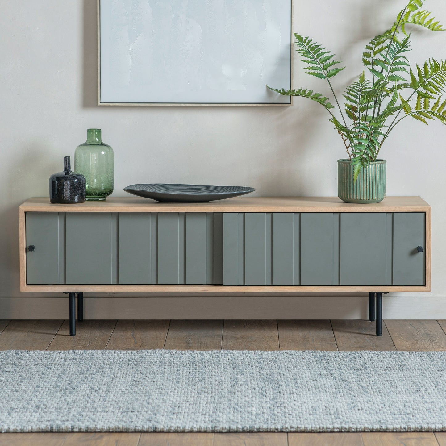 A grey and wood sideboard with a plant on it.