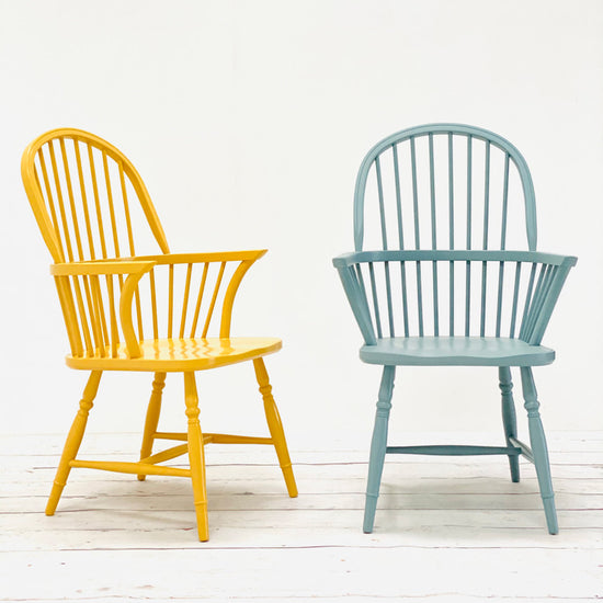 A pair of Kiki Spindle Back Arm Chairs in yellow and blue, perfect for interior decor in a home.