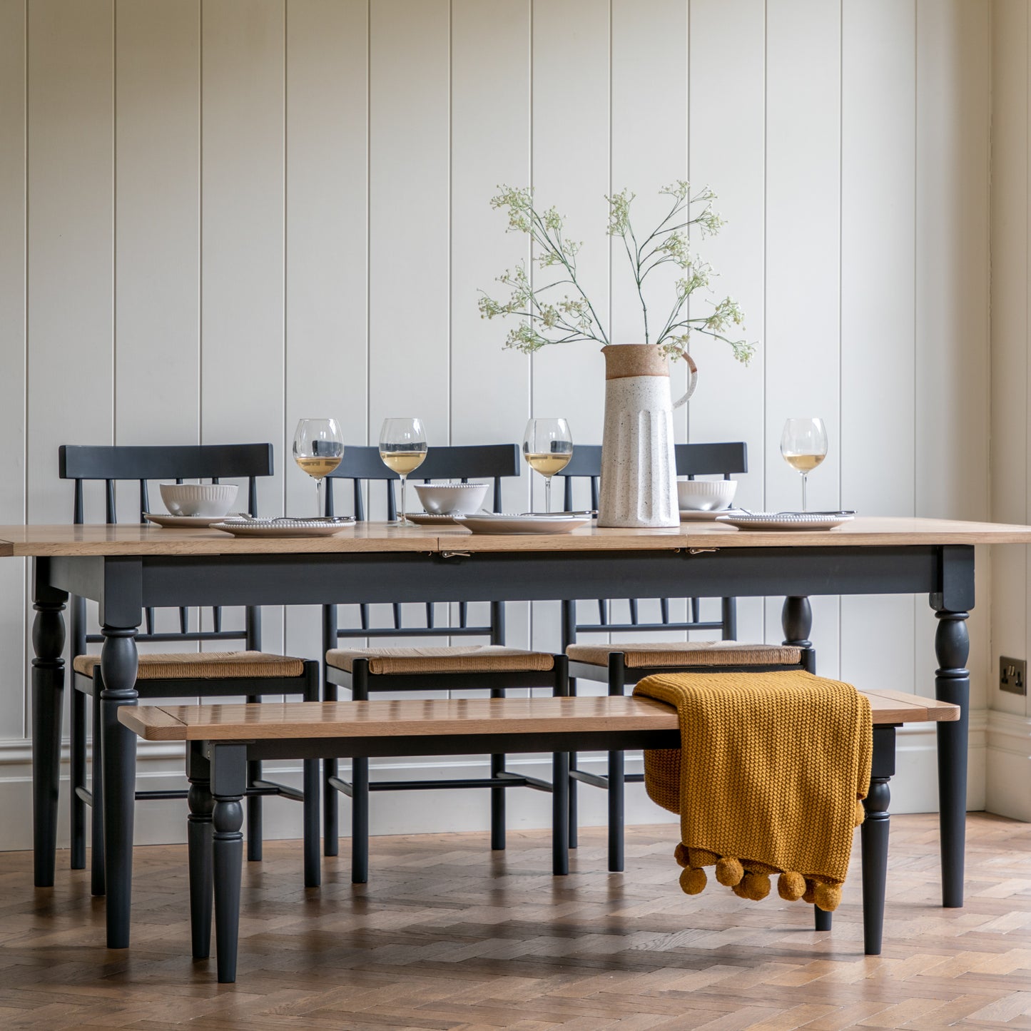 A Buckland Extending Dining Table from Kikiathome.co.uk, perfect for home furniture and interior decor, includes chairs and a bench.
