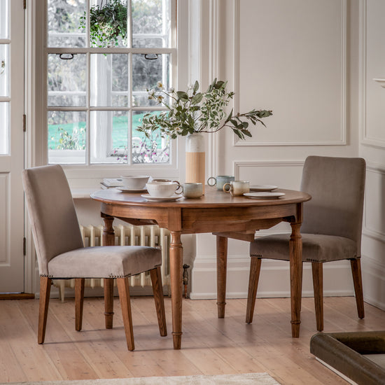 A dining room furnished with stylish interior decor and home furniture including a Sweaton Extending Round Table and chairs from Kikiathome.co.uk.