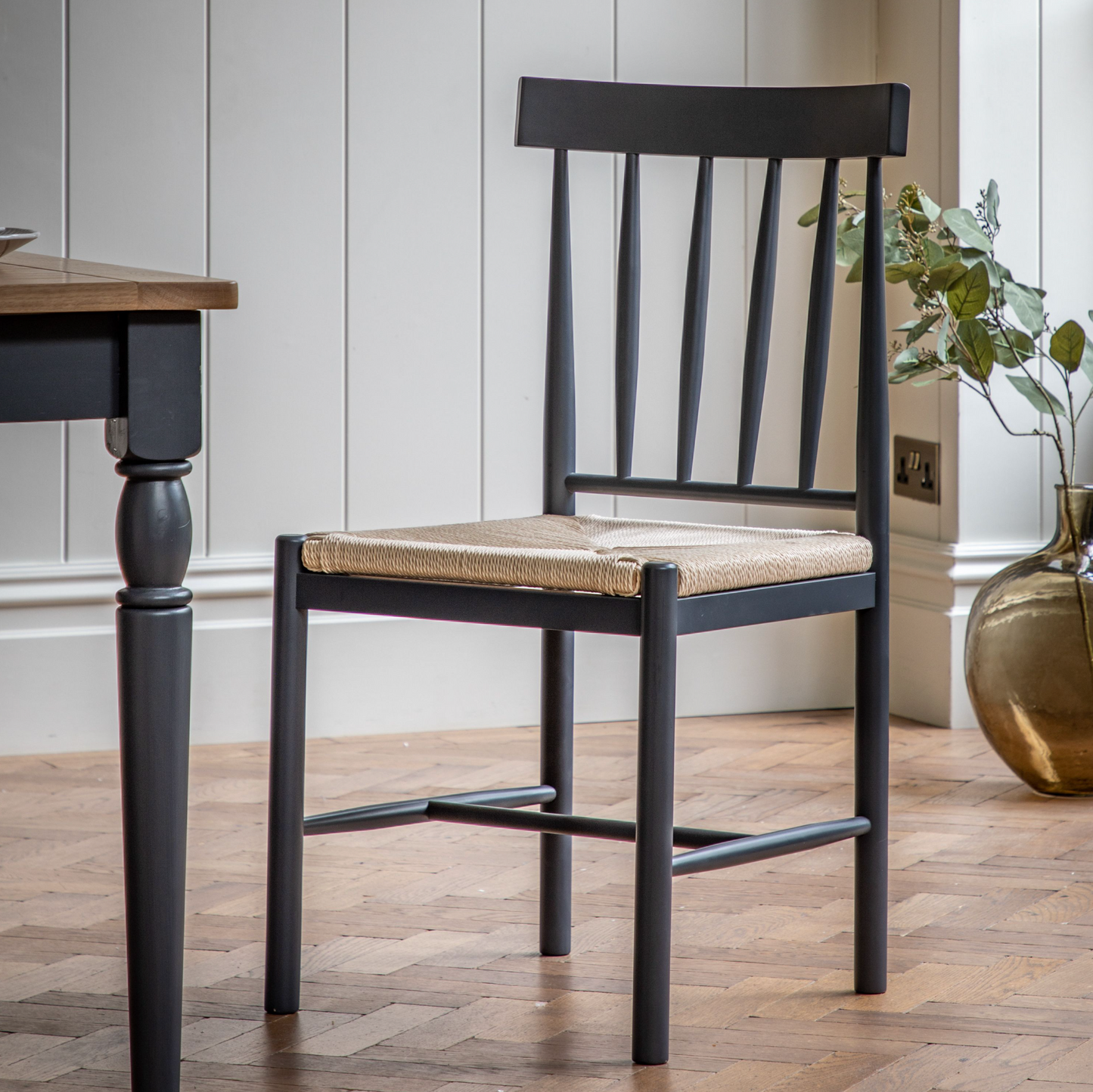 A pair of Buckland Dining Chairs in Meteor, featuring a wicker seat, for interior decor and home furniture enthusiasts.