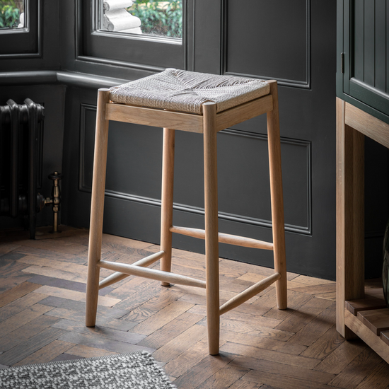 A Home furniture Buckland Oak Stool by Kikiathome.co.uk in front of a window.