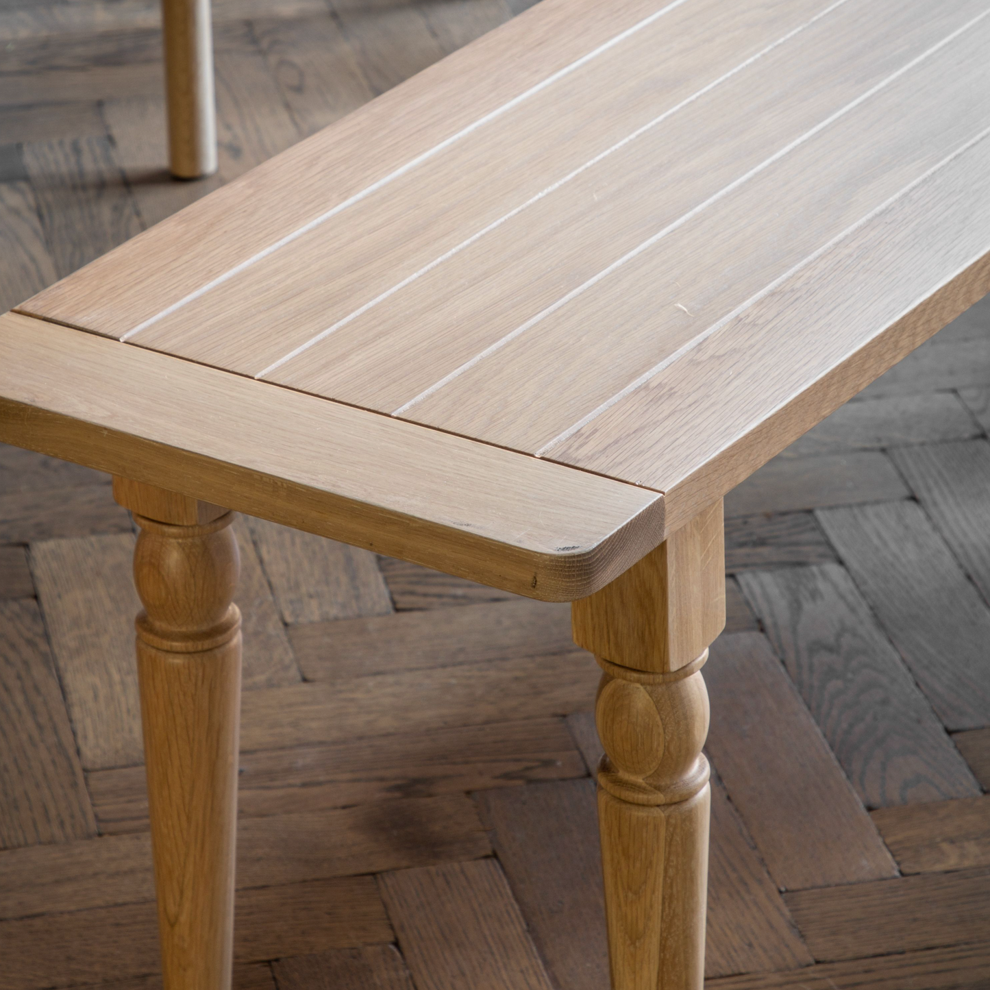 A Buckland oak dining bench from Kikiathome.co.uk adds interior decor to a wooden floor.