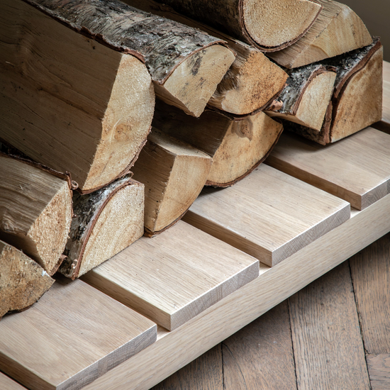 Load image into Gallery viewer, A stack of logs as interior decor on a wooden shelf.
