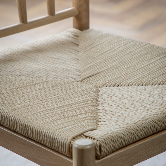 A close up of the Kikiathome.co.uk Buckland Bar Stool in Oak 2pk with a woven seat, perfect for interior decor.
