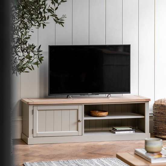 A stylish living room adorned with a Prairie Buckland Media Unit from Kikiathome.co.uk atop a wooden cabinet, enhancing the home's interior decor.