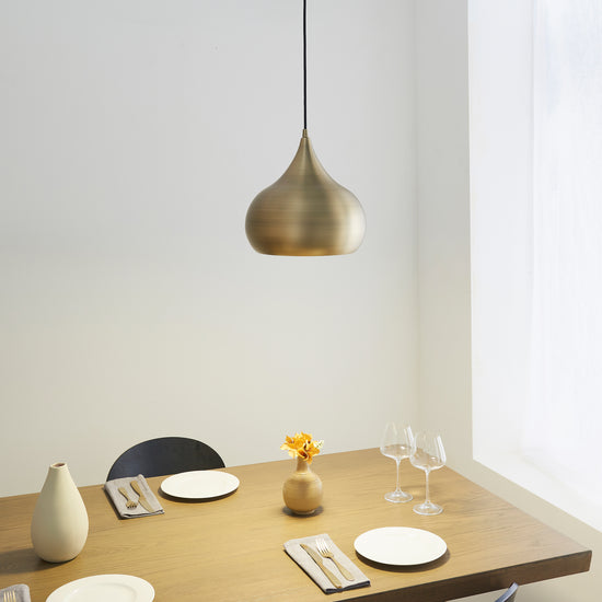 A dining room showcasing a Brosser Pendant Light Antique Brass from Kikiathome.co.uk along with stylish table and chairs, enhancing the home's interior decor.
