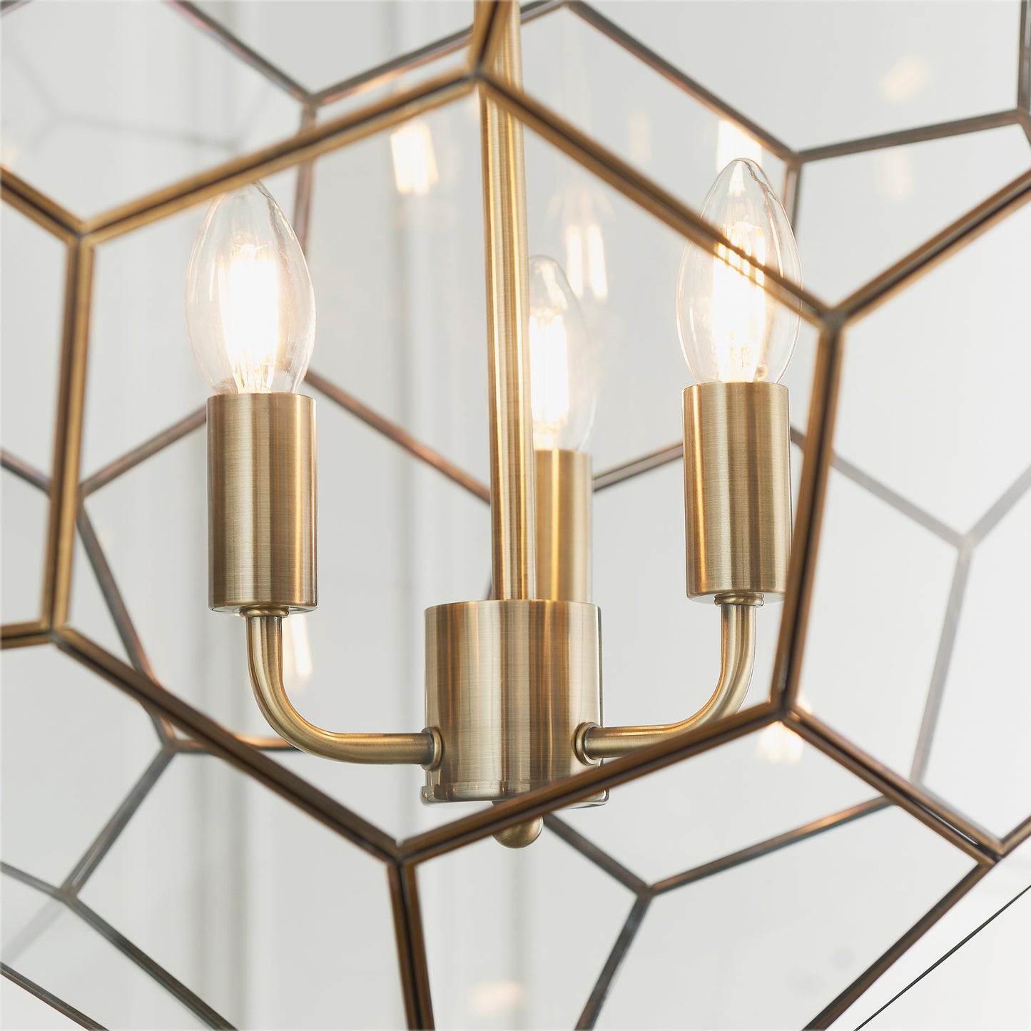 A Miele 3 Pendant Light Antique Brass with a geometric shape perfect for interior decor.
