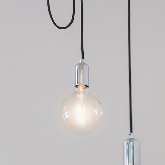 Three Studio 6 Cluster Pendant Light Chrome hanging from a chain on a white wall for interior decor.