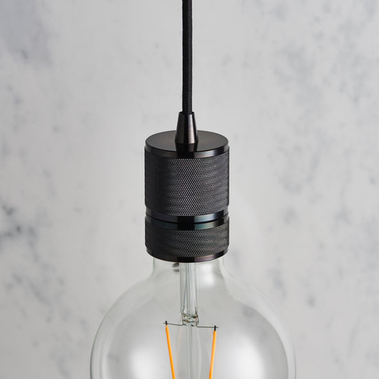An Urban Pendant Light in Black Chrome hung on a marble table, perfect for interior decor and home furniture from Kikiathome.co.uk.