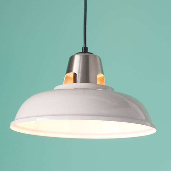 A white Staverton Shade Taupe pendant light hanging on a turquoise background, adding elegance to your interior decor.