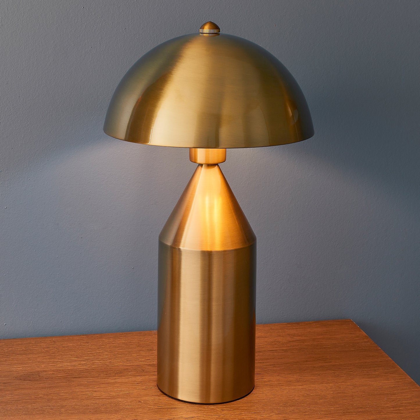 A Nova 1 Table Light Antique Brass as interior decor on a wooden table from Kikiathome.co.uk.