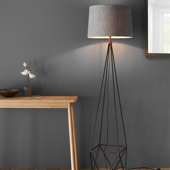 A Bow 1 Floor Light with a grey shade and a wooden table, perfect for interior decor.