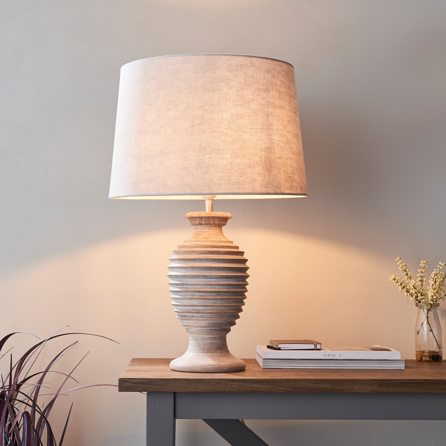A Sagara 1 Table Light by Kikiathome.co.uk, an interior decor piece, placed on a table next to a plant.