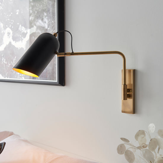 A bedroom with a Navren 1 Wall Light as part of its interior decor.