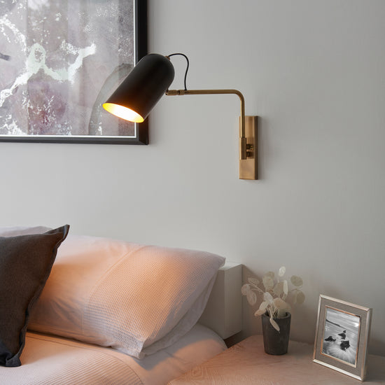A stylish bed adorned with a Navren 1 Wall Light, perfect interior decor for your home.