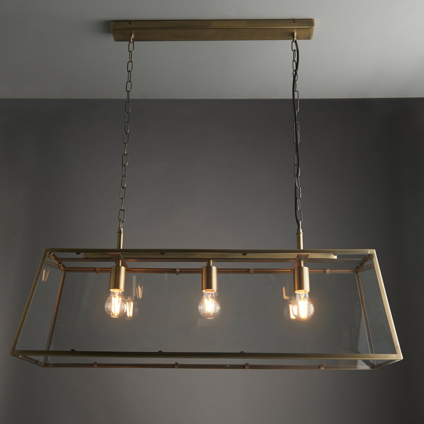 A Hurst 3 Pendant Light Antique Brass, perfect for interior decor and home furniture, featuring three hanging bulbs.