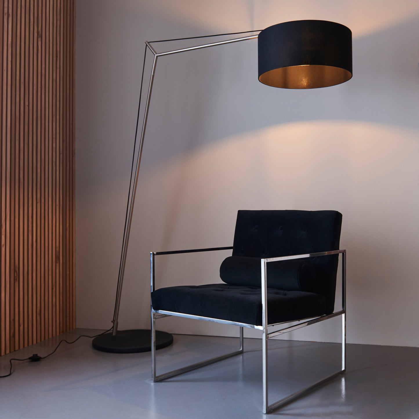 A black chair paired with a Kikiathome.co.uk Buckland Floor Lamp Antique Nickel enhances interior decor.