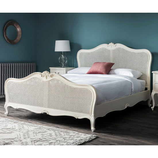 A Holne 5' Cane Bed Vanilla White by Kikiathome.co.uk, perfect for interior decor and home furniture enthusiasts, featuring a carved headboard and footboard.