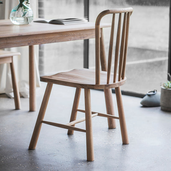 A pair of Tigley Dining Chairs by Kikiathome.co.uk, complementing a wooden dining table in a room with a window - perfect for interior decor.