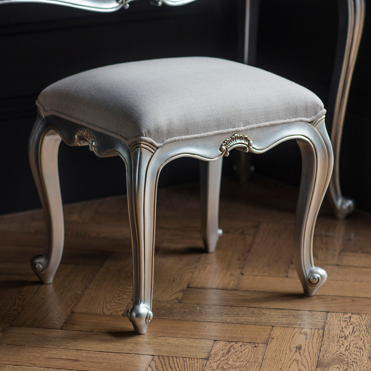 A Holne Dressing Stool Silver 470x450x400mm upholstered stool with a mirror on top from Kikiathome.co.uk, perfect for interior decor.