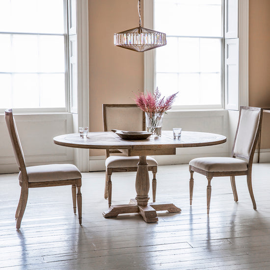 A dining room furnished with interior decor and home furniture, including a Belsford Round Extendable Dining Table and chairs from Kikiathome.co.uk.
