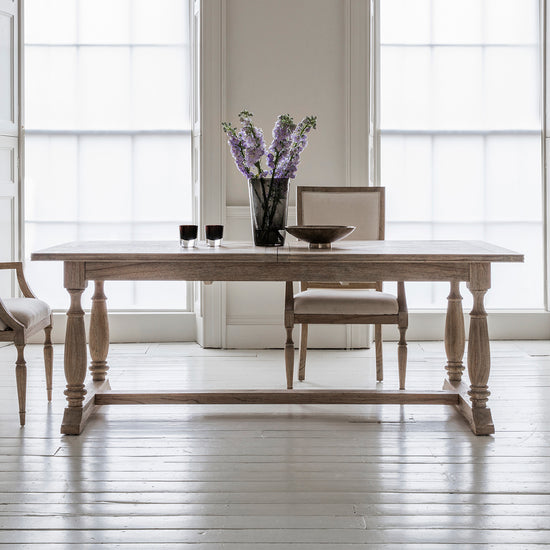 Interior decor, Home furniture: A Belsford Extending Dining Table 2500x1000x750mm serving as a centerpiece for room's interior decor, complemented by a vase of flowers