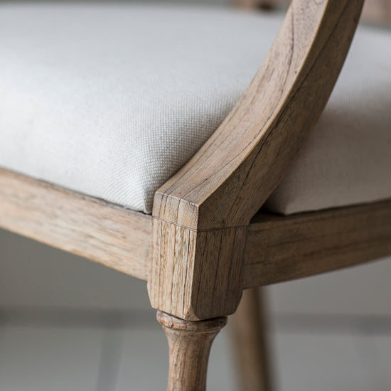 A close up of a Belsford Arm Chair from Kikiathome.co.uk with a beige upholstered seat, perfect for interior decor or home furniture.