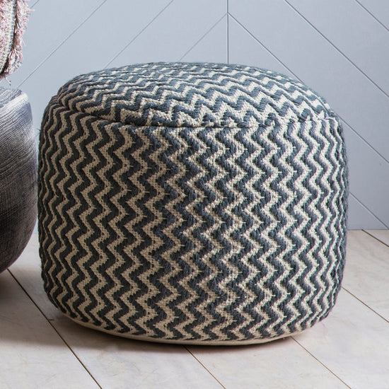 A Kikiathome.co.uk Kidley Pouffe Grey complements interior decor, placed on a wooden floor.