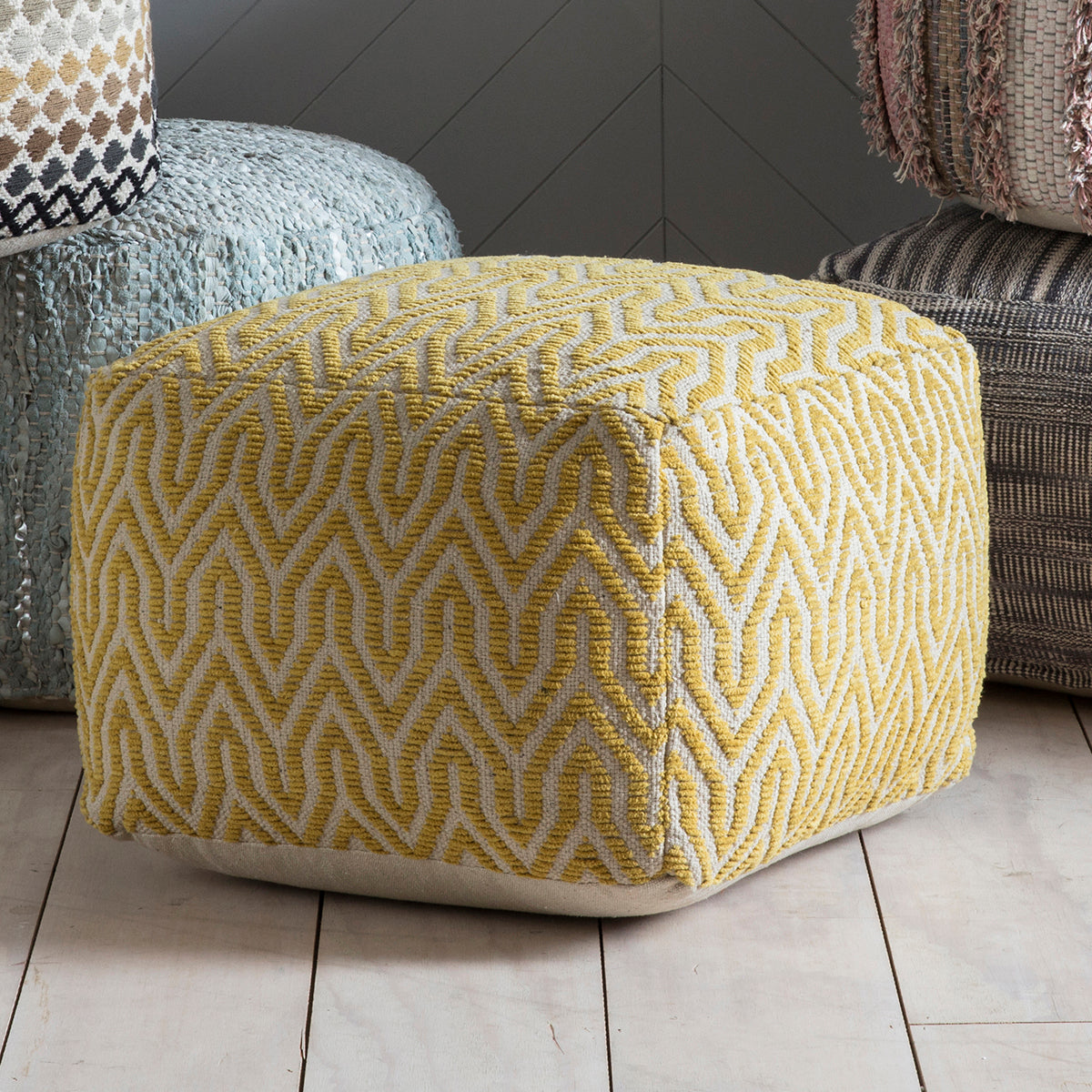 Load image into Gallery viewer, A yellow and grey Stromstad Pouffe Ochre sitting on top of a wooden floor from Kikiathome.co.uk, perfect for interior decor and home furniture.
