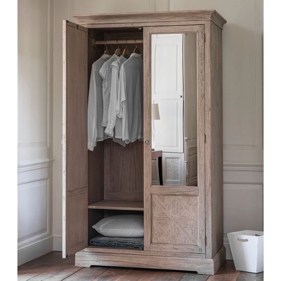 A Belsford 2 Mirror Door Wardrobe for home furniture and interior decor purposes, with clothes hanging on it.